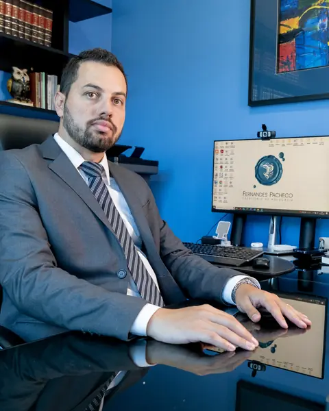 Felipe Augusto Sartori Pacheco, sentado à mesa no escritório
